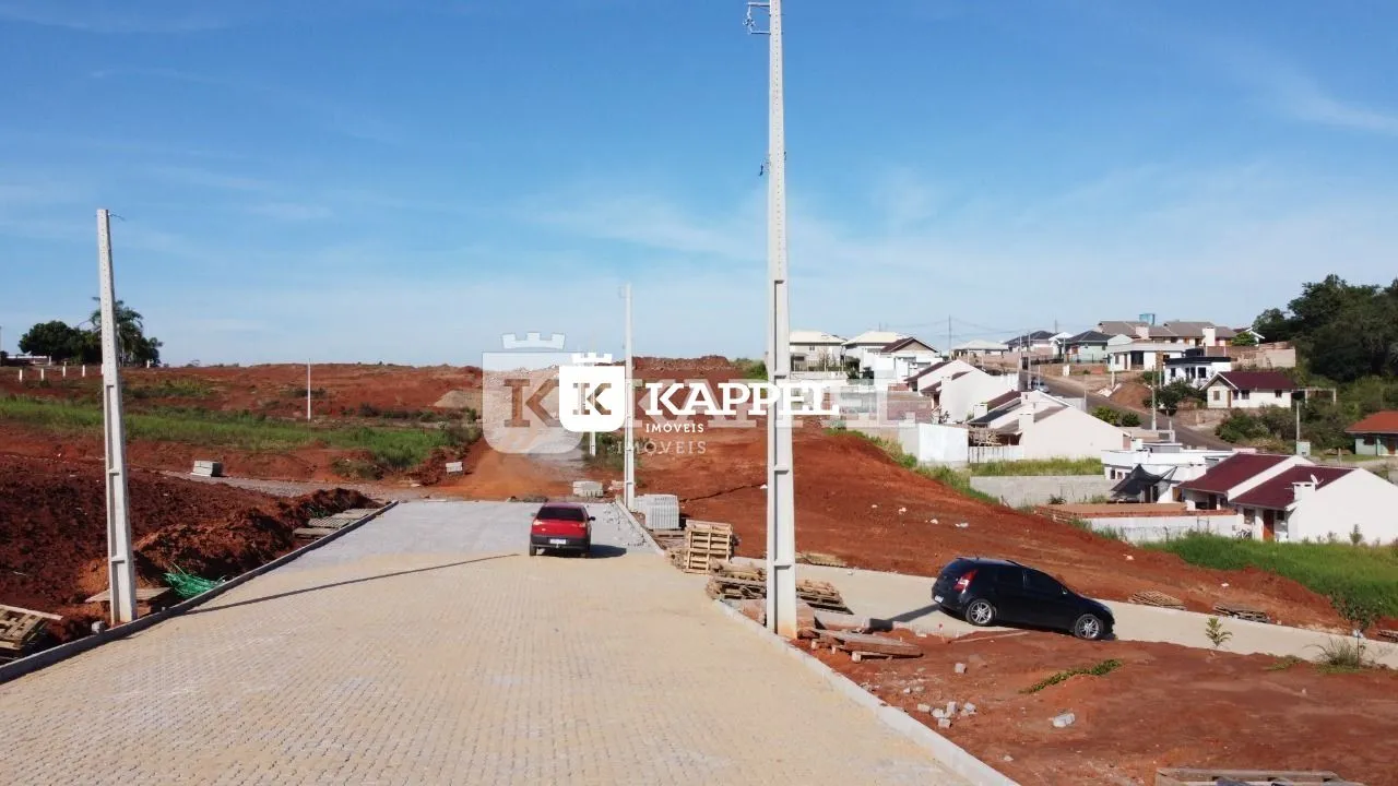 Vista da entrada de uma propriedade em Lajeado, Brasil, mostrando uma estrada de acesso de terra vermelha.