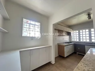 Ambiente interno de uma sala com janelas e armários brancos.
