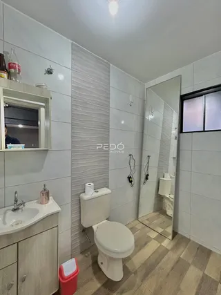 Foto de um banheiro com revestimento cerâmico e espelho.