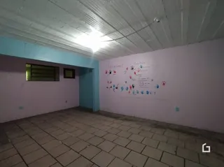 Ambiente interno de uma sala com piso de cerâmica e parede decorada.