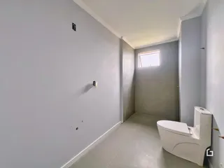 Corredor interno com paredes cinzas e piso claro de cerâmica.