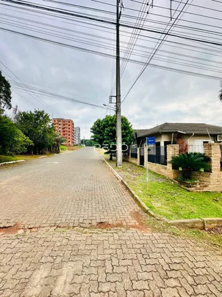 Vista da fachada de uma propriedade em Lajeado, Brasil, com rua e muro de contenção.