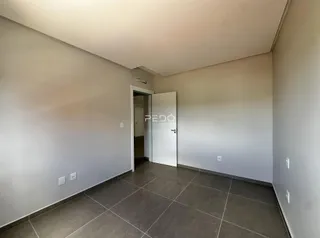 Hall de entrada com piso de cerâmica e portas brancas.