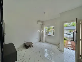 Ambiente interno moderno com piso de mármore claro e paredes brancas.