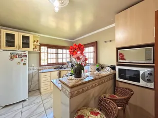Vista interna de uma cozinha com armários e bancada em Lajeado.