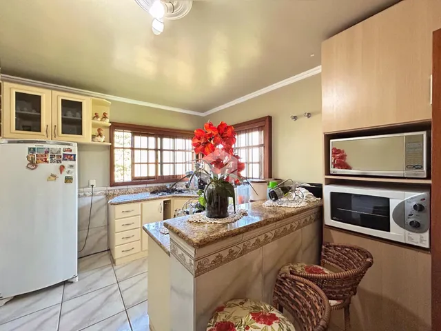 Vista interna de uma cozinha com armários e bancada em Lajeado.
