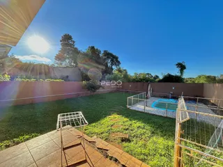 Vista de um quintal gramado com piscina e cerca em Lajeado.