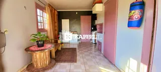 Uma sala de estar com piso de madeira e uma mesa rústica.