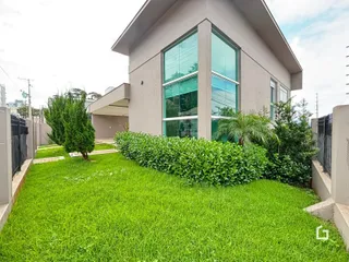 Fachada de uma casa moderna com jardim verde bem cuidado.