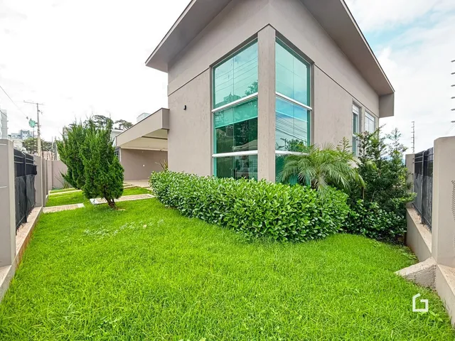 Fachada de uma casa moderna com jardim verde bem cuidado.