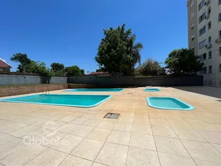 Área externa com duas piscinas e piso de cerâmica.