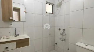 Foto de um banheiro com revestimento cerâmico branco.