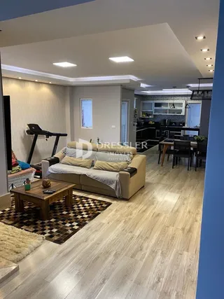 Sala de estar com piso de madeira clara e sofá.