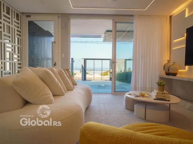 Sala de estar moderna com portas de vidro que oferecem vista para o exterior.
