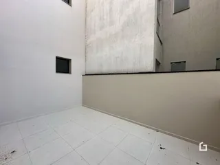 Foto de um ambiente interno com paredes brancas e piso de cerâmica.