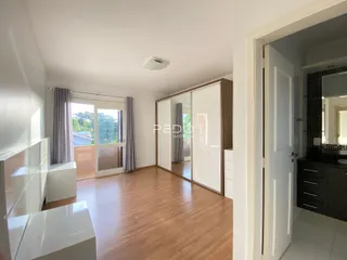 Sala de estar com piso de madeira e portas de vidro que dão acesso ao exterior.