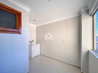 Imagem de um corredor interno com revestimento de piso cerâmico claro.