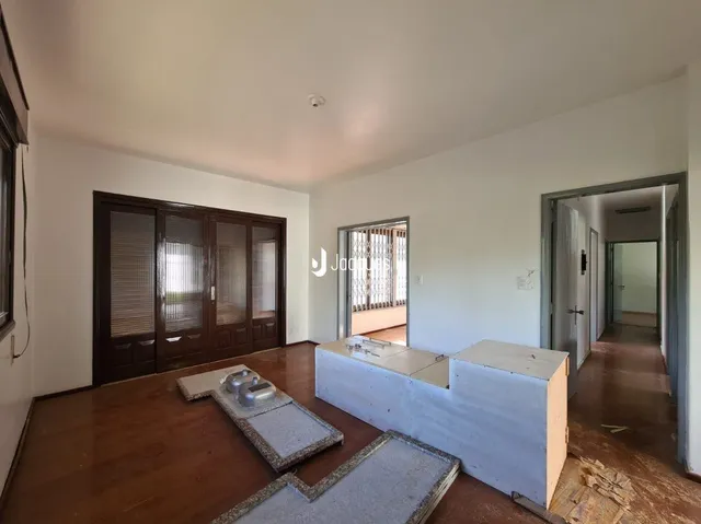 Interior de uma sala com piso de madeira e portas de madeira.