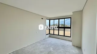 Uma foto de um cômodo vazio com paredes brancas e piso de concreto.