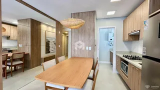 Uma sala de jantar com mesa de madeira e cadeiras em um apartamento.