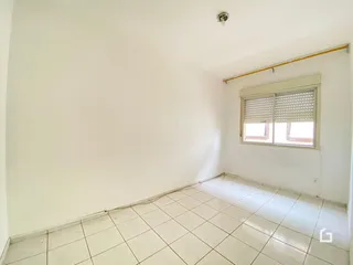 Ambiente interno de uma sala com piso de cerâmica clara.