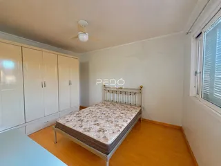 Quarto com armários embutidos e piso de madeira clara.