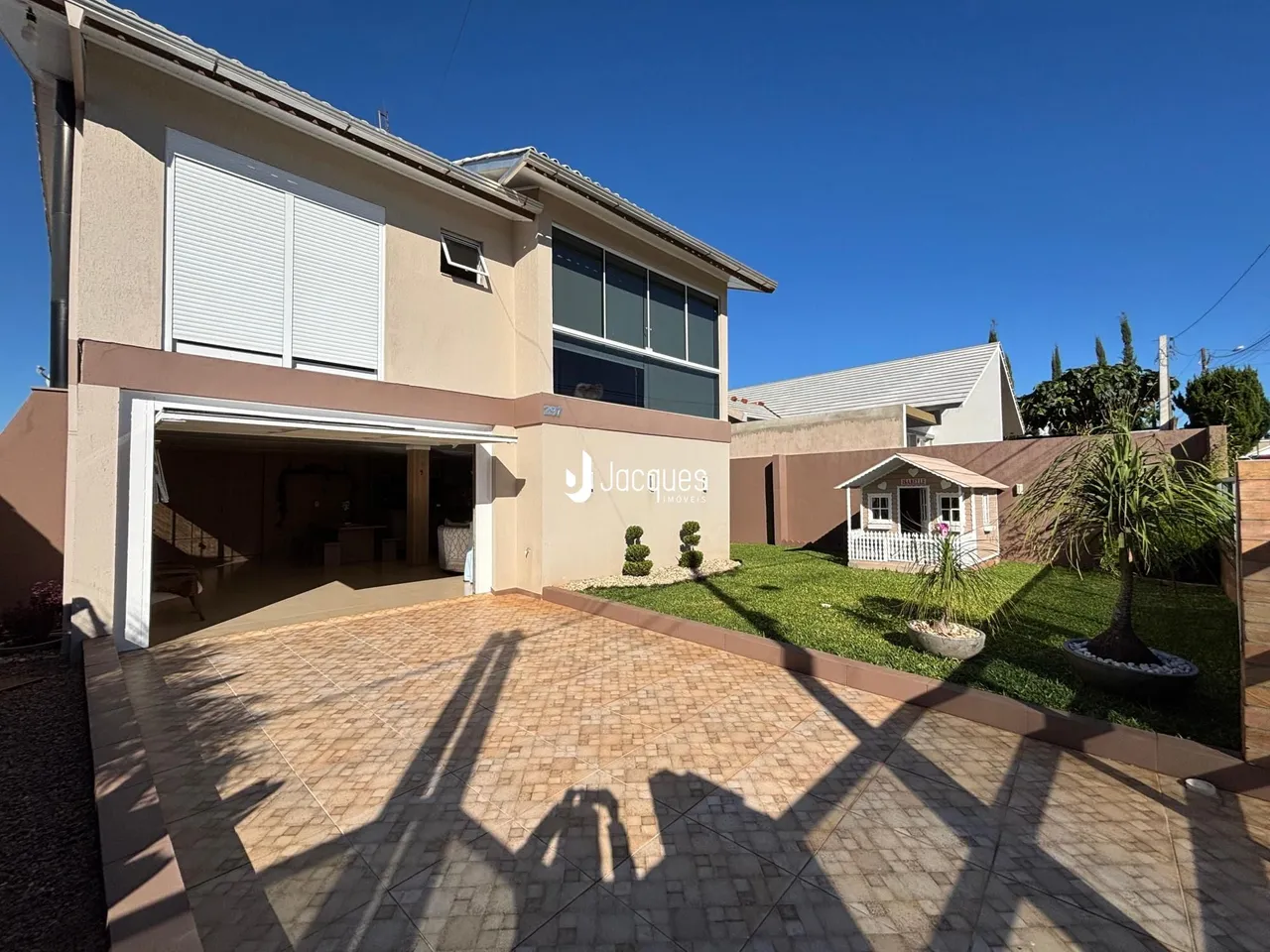 Fachada de uma casa em Lajeado, Brasil, com entrada coberta e jardim.