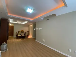 A sala de estar apresenta piso de madeira e iluminação moderna.