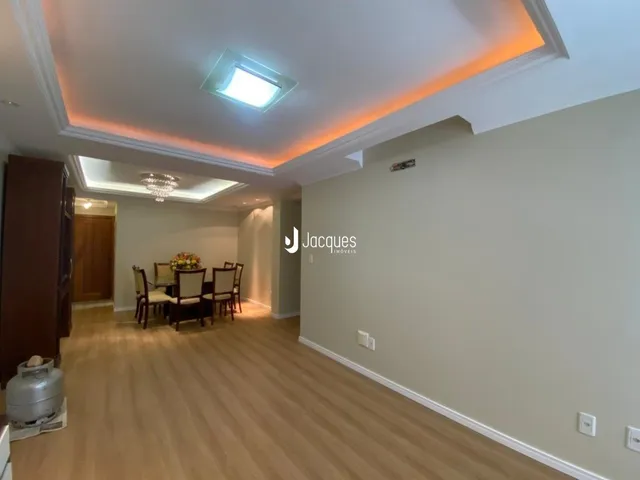 A sala de estar apresenta piso de madeira e iluminação moderna.
