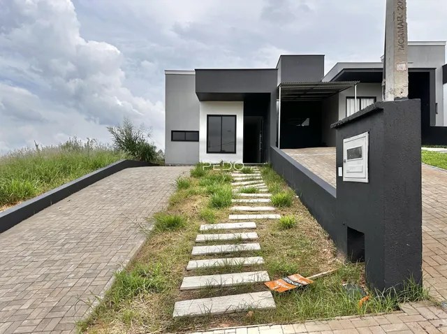 Vista da fachada de uma residência moderna em Lajeado, Brasil, com caminho de acesso.