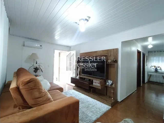 Sala de estar com sofá e painel de madeira na Lajeado.