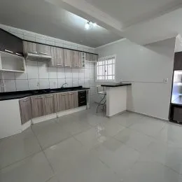 Foto interna de uma cozinha com armários e piso claro.