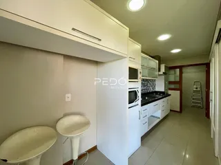 Ambiente interno mostrando uma cozinha e área de passagem com louças sanitárias.