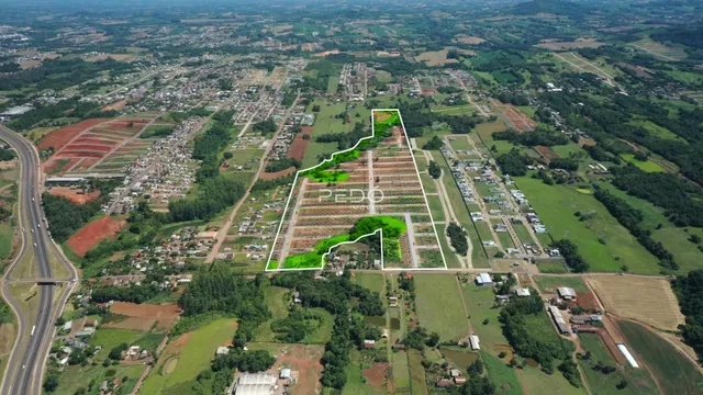 Vista aérea de uma propriedade rural com áreas de cultivo e vegetação.