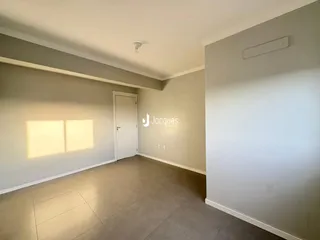 Interior de uma sala com piso de cerâmica e paredes claras.