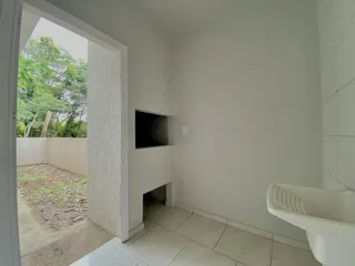 Interior de um ambiente com piso de cerâmica e acesso a uma área externa.