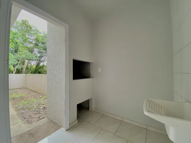Interior de um ambiente com piso de cerâmica e acesso a uma área externa.