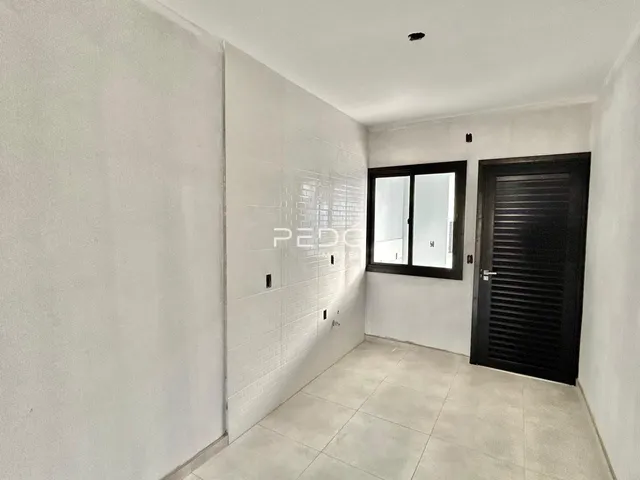Corredor interno com paredes brancas e piso de cerâmica.
