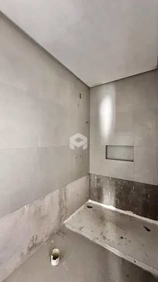 A foto mostra um interior com paredes de concreto aparente.