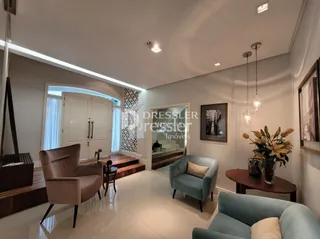 Sala de estar com piso de madeira e grandes janelas.