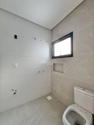 Foto de um banheiro moderno com piso de mármore claro e vaso sanitário.