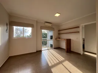 Sala de estar com piso de cerâmica e porta de vidro que dá acesso ao exterior.