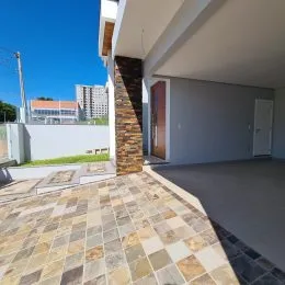 Piso externo de ladrilhos claros em uma área pavimentada de uma residência.