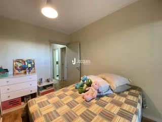 Quarto com cama e cômoda.
