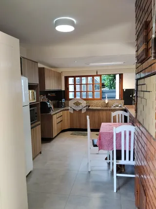 Foto de uma cozinha com armários de madeira e mesa de jantar em um imóvel.