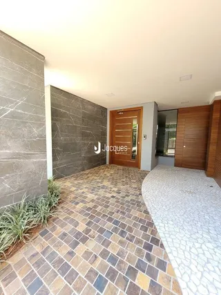 Hall de entrada com piso de ladrilhos no interior de uma residência.