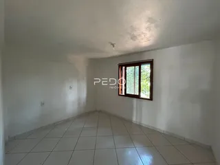 Corredor interno de um imóvel com piso de cerâmica e paredes brancas.