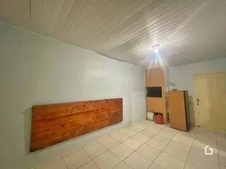 Vista de um corredor com piso de cerâmica e painel de madeira na propriedade.
