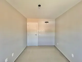 Hall de entrada com paredes brancas e piso claro.