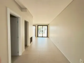 Hall de entrada com paredes brancas e piso claro.
